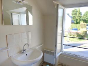 een badkamer met een wastafel, een spiegel en een raam bij Apartment Le Petit Robinson-3 by Interhome in La Richardais