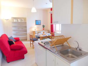 cocina con sofá rojo y mesa en Apartment Le Petit Robinson-6 by Interhome, en La Richardais