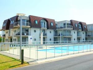 a large building with a swimming pool in front of it at Apartment Estepona with parking by Interhome in Mispelburg