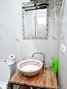 a white toilet sitting next to a sink in a bathroom at Tirana City Centre Folk Villa in Tirana