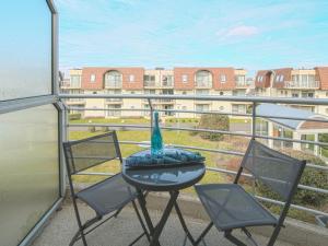 a balcony with two chairs and a table with a vase on it at Apartment Oase with parking by Interhome in Mispelburg
