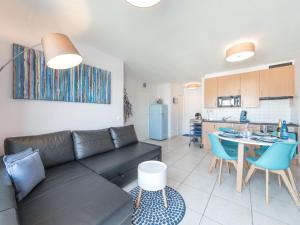 a living room with a couch and a table and a kitchen at Apartment Oase with parking by Interhome in Mispelburg