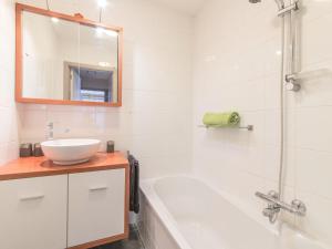 y baño con lavabo, bañera y espejo. en Apartment Residentie Maritiem by Interhome, en Bredene