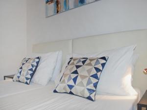Una cama con almohadas azules y blancas. en Studio Shina App- 8 by Interhome, en Lugano