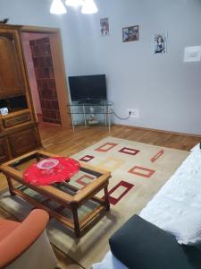 a living room with a coffee table and a tv at Apartament cu trei camere in Băile Herculane
