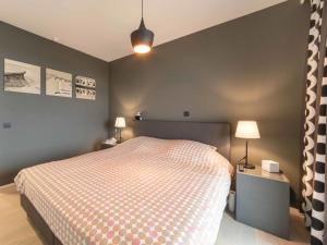 1 dormitorio con 1 cama, 2 mesas y 2 lámparas en Apartment Victoria by Interhome, en Ostende