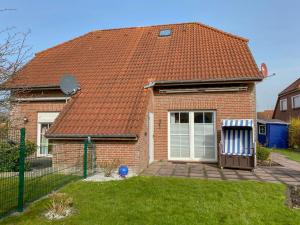 a brick house with a red roof at Holiday Home Sandmuschel by Interhome in Norddeich