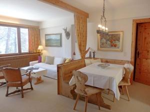 un soggiorno con tavolo e divano di Apartment Chesa Cripels II by Interhome a Sankt Moritz
