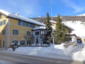 un edificio giallo con neve di fronte a una strada di Apartment Chesa Cromer by Interhome a Celerina