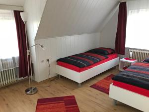ノルデンにあるApartment Juist by Interhomeのベッドルーム1室(赤と黒の枕が付くベッド1台付)