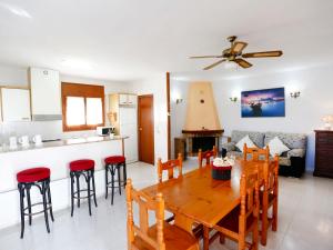 a kitchen and living room with a wooden table and chairs at Holiday Home Sandra by Interhome in Riumar