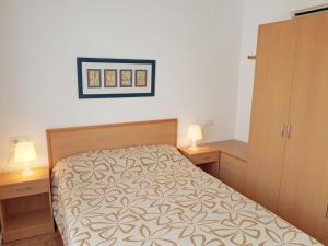 サン・カルラス・デ・ラ・ラーピタにあるApartment Simanca by Interhomeのベッドルーム1室(ベッド1台、ナイトスタンド2つ、ランプ2つ付)