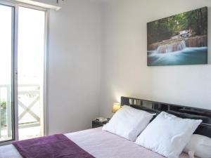 a bedroom with a bed with a painting on the wall at Apartment Grand Pavois-5 by Interhome in Mimizan-Plage