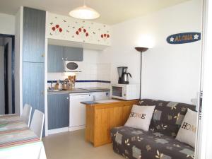 a living room with a couch and a kitchen at Apartment Grand Pavois-5 by Interhome in Mimizan-Plage