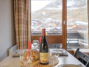 a bottle of wine sitting on a table with glasses at Studio Le Grand Pré-5 by Interhome in Tignes