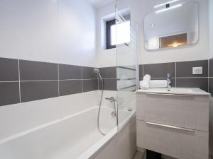 La salle de bains est pourvue d'une douche, d'un lavabo et d'une baignoire. dans l'établissement Apartment Les Tommeuses - Val Claret-32 by Interhome, à Tignes