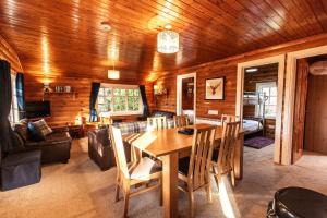 a dining room and living room with a table and chairs at 3 Bedroom Log Cabin in Snowdonia nr MTB trails in Tanygrisiau