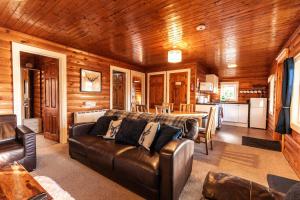 a living room with a couch and a kitchen at 3 Bedroom Log Cabin in Snowdonia nr MTB trails in Tanygrisiau