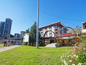 a building with a pole in front of a grass field at Apartment Chanteneige 301 by Interhome in Les Menuires