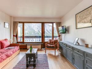 ein Wohnzimmer mit einem Sofa und einem Tisch in der Unterkunft Apartment Le Bec Rouge - Le Lac-5 by Interhome in Tignes