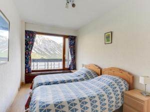 een slaapkamer met twee bedden en een raam bij Apartment Le Bec Rouge - Le Lac-5 by Interhome in Tignes