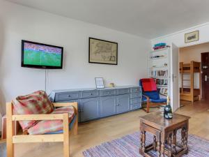 ein Wohnzimmer mit einem TV an der Wand in der Unterkunft Apartment Le Bec Rouge - Le Lac-5 by Interhome in Tignes