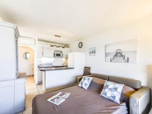 a living room with a couch and a kitchen at Apartment Arius by Interhome in Cavalaire-sur-Mer