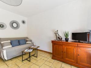 a living room with a couch and a flat screen tv at Studio Antares-2 by Interhome in Cavalaire-sur-Mer