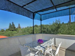 een tafel en stoelen op een balkon met een blauwe parasol bij Apartment Cico-9 by Interhome in Selca kod Bogomolja +11 foto's