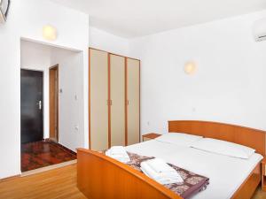 een slaapkamer met een groot bed met witte lakens bij Apartment Cico-5 by Interhome in Selca kod Bogomolja