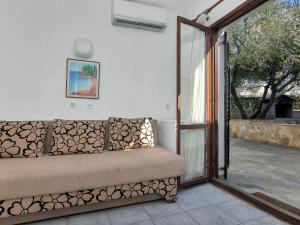 a couch in a room with a sliding glass door at Apartment Cico-8 by Interhome in Selca kod Bogomolja