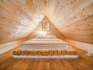 a bed in a log cabin with a window at Chalet Plitvice II by Interhome in Rudanovac