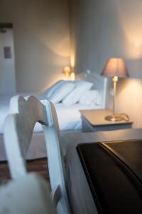 una camera da letto con un letto e un tavolo con una lampada di HOTEL DE FRANCE - Hôtel de charme en Provence a Saint-Maximin-la-Sainte-Baume