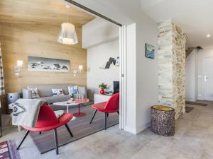a living room with red chairs and a couch at Apartment Les Hauts du Val Claret - Val Claret-21 by Interhome in Tignes
