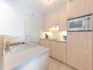 a kitchen with a sink and a microwave at Apartment Queen Mary 302 with balcony by Interhome in Bredene