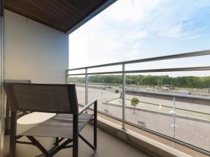 a chair on a balcony with a view of a street at Apartment Apartment 302 by Interhome in Bredene