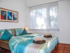 a bedroom with a bed with two stuffed animals on it at Apartment Condominio Les Hirondelles by Interhome in Orselina