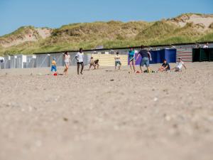 MispelburgにあるApartment Sea Garden by Interhomeの浜辺でサッカーをしている人々の集団