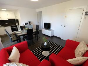 a living room with a red couch and a kitchen at Apartment Formentor II by Interhome in Salou