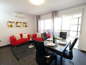 a living room with a table and a red couch at Apartment Formentor II by Interhome in Salou