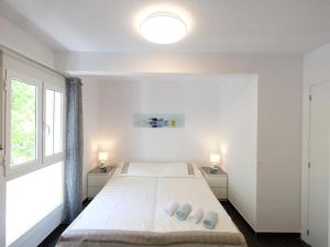 サロウにあるApartment Formentor by Interhomeの白いベッドルーム(大型ベッド1台、窓2つ付)