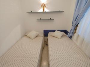 two beds in a small room with blue curtains at Apartment Costa Blanca II by Interhome in Cambrils
