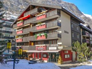 un grand bâtiment avec balcon dans la neige dans l'établissement Apartment Bellevue-6 by Interhome, à Zermatt