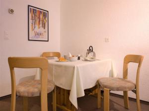 ツェルマットにあるApartment Bellevue-6 by Interhomeの白いテーブルクロスと椅子2脚付きのテーブル