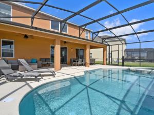 a swimming pool with a patio and a house at Villa Crofton Villa by Interhome in Loughman