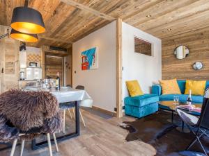 a living room with a table and a blue couch at Apartment Super Tignes-1 by Interhome in Tignes