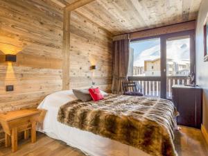 1 dormitorio con 1 cama con pared de madera en Apartment Super Tignes-1 by Interhome en Tignes