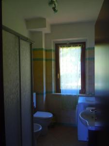パッシニャーノ・スル・トラジメーノにあるLa Finestra sul Lagoのバスルーム(トイレ、洗面台付)、窓が備わります。
