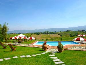 una piscina en un campo con sombrillas en Holiday Home Borgo Fontana-7 by Interhome, en Cerreto Guidi