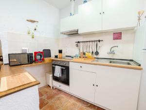 - une cuisine avec des placards blancs et un évier dans l'établissement Holiday Home Cueva de Lindaraja by Interhome, à Grenade